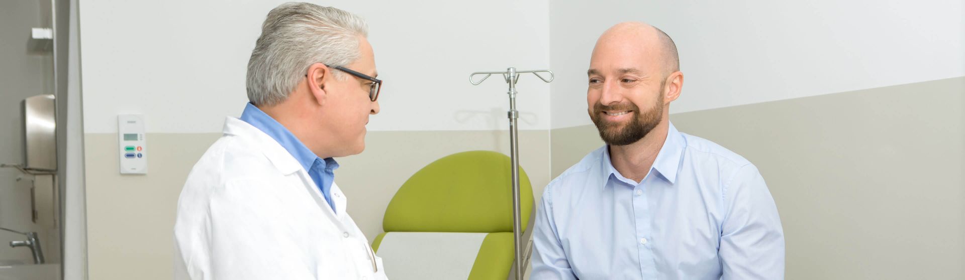 Urologe führt mit einem Patienten ein Gespräch in seiner Ordination.